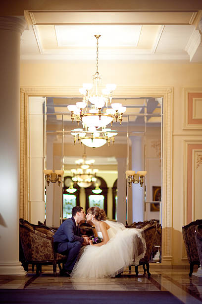 bride and groom in the golden hall stock photo