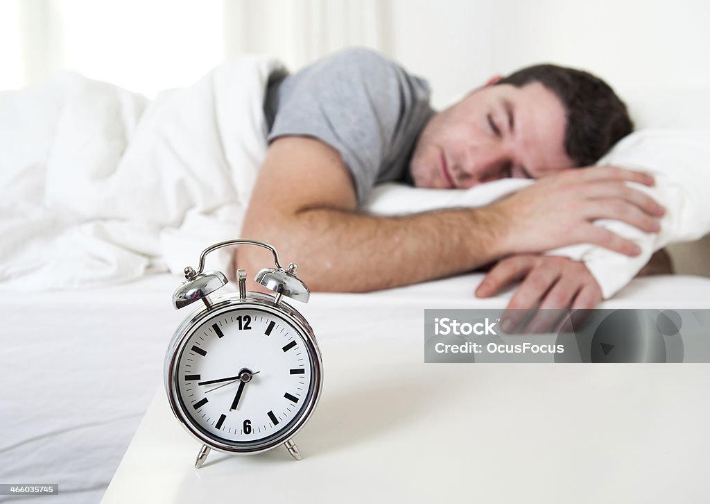 Joven atractivo hombre durmiendo en la cama - Foto de stock de Acogedor libre de derechos