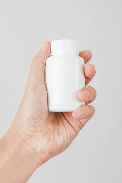 istock Holding a white bottle of pills 466037328