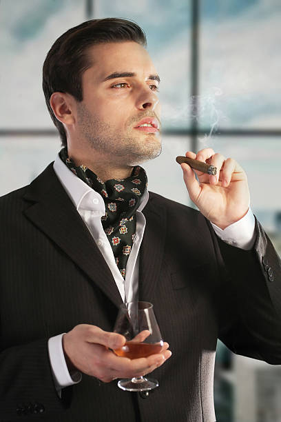 男性喫煙葉巻と飲むコニャック ストックフォト