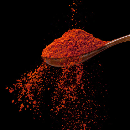Cayenne pepper is flowing-photographed  on black background 