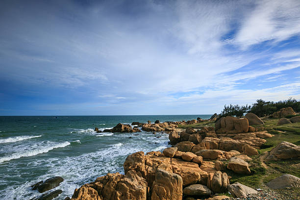 istock Waves crashing on rocky shore in the sunset 466044172