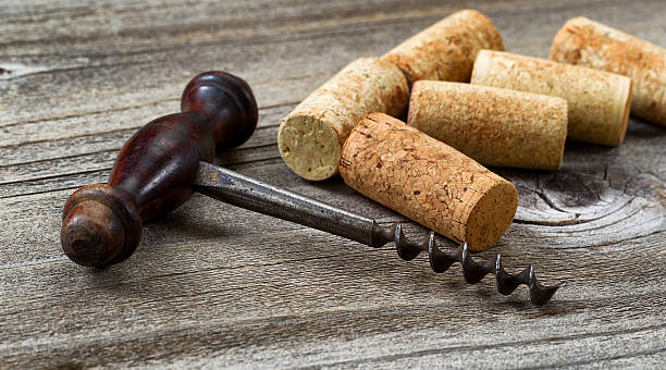 istock Old corkscrew with used corks in background on aged wood 466045692