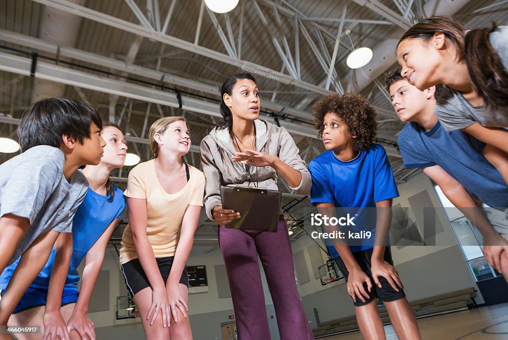 Group of children with coach in school gym Multi-ethnic group of children with coach in school gym. Coach Stock Photo