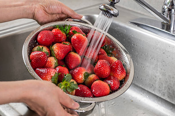 istock A silver colander full of strawberries being rinsed 466050454