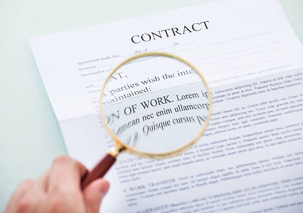 istock Hand Holding Magnifying Glass Over Contract 466050571