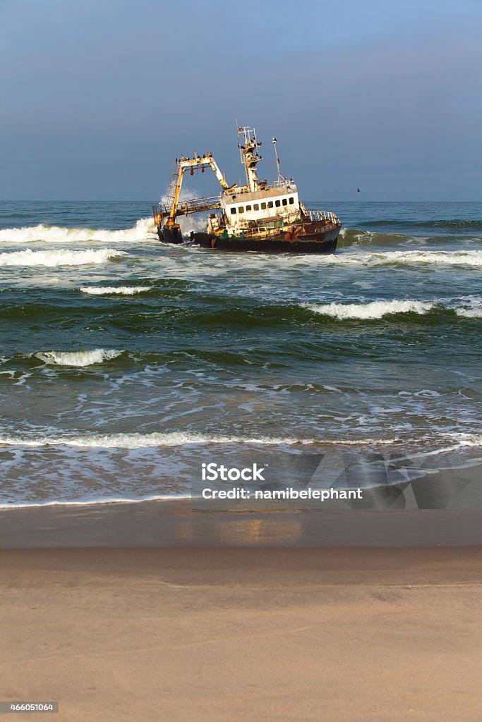 wreck at the skeleton coast Waves breaking against a wreck with cormorants sitting on the ship at the Skelton Coast, Namibia 2015 Stock Photo