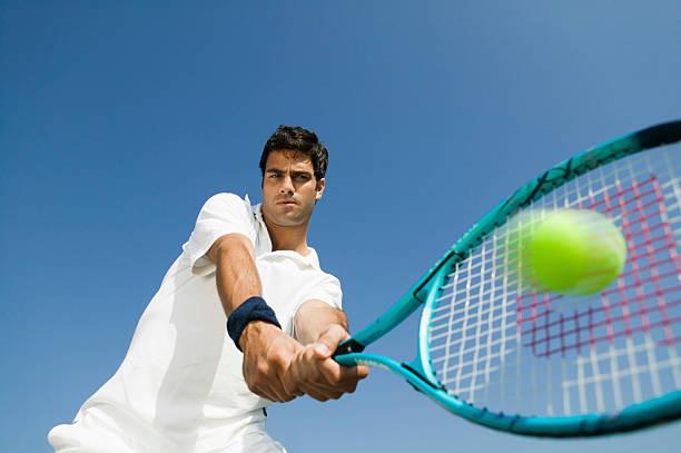 istock Determined Man Playing Tennis Against Sky 466051729