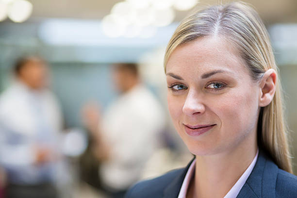 istock Pretty Businesswoman posing while colleagues talking together in background 466054821