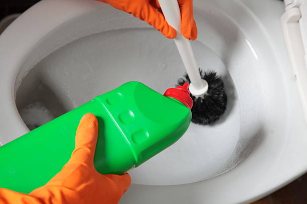 istock Gloved hand cleaning toilet bowl using brush 466057221