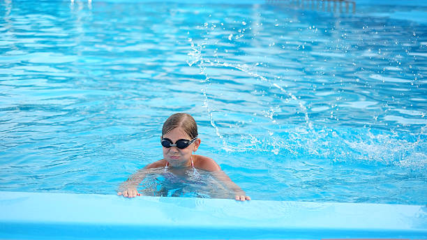 istock Cute girl with goggles in swimming pool 466058856