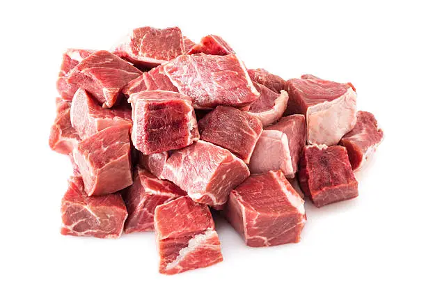 Beef Stew Meat Raw - diced raw blade or chuck steak, on white background.
