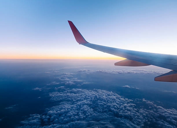 Airplane Wing in Flight view from airplane in flight. stratosphere airplane cloudscape mountain stock pictures, royalty-free photos & images