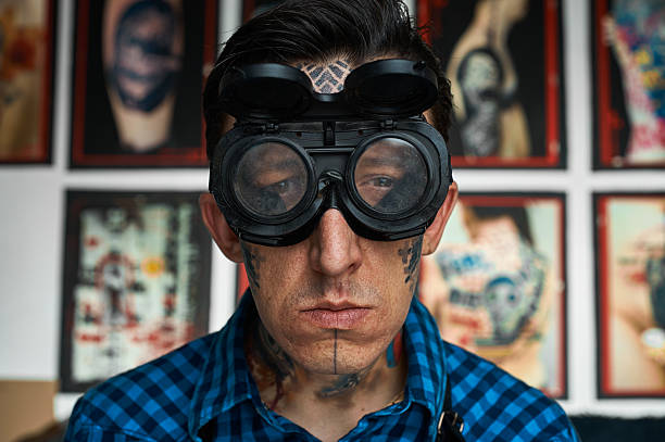 Portrait of tattoo artist in welder glasses Closeup portrait of tattoo artist in welder glasses shoulder tattoo designs for men stock pictures, royalty-free photos & images