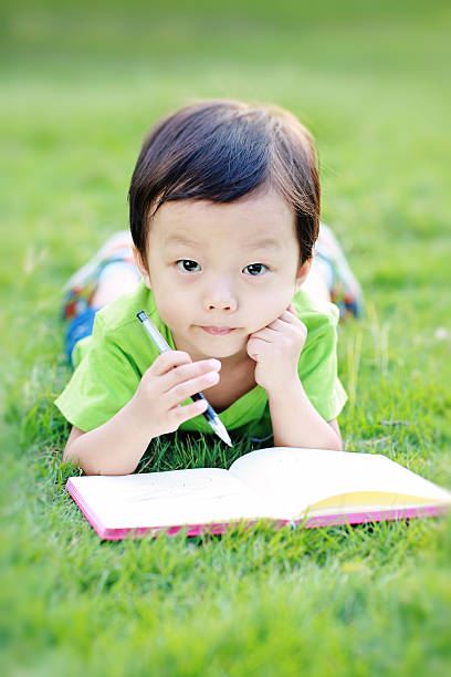 istock The children read a book on the grass 466062530