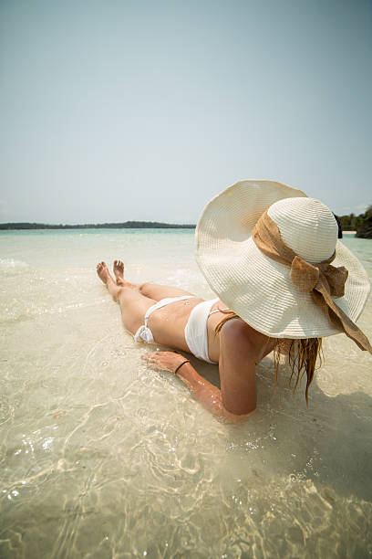 istock Young woman on tropical vacation lying down in water 466063308