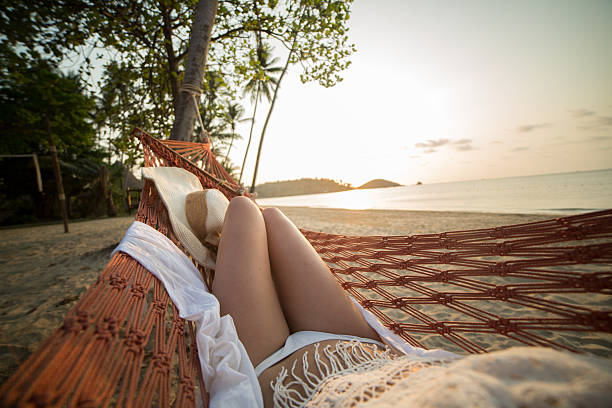 istock Woman watching sunset from hammock on exotic beach 466063352