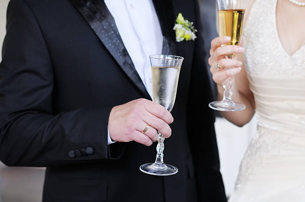 istock Bride and groom holding glasses 466064283