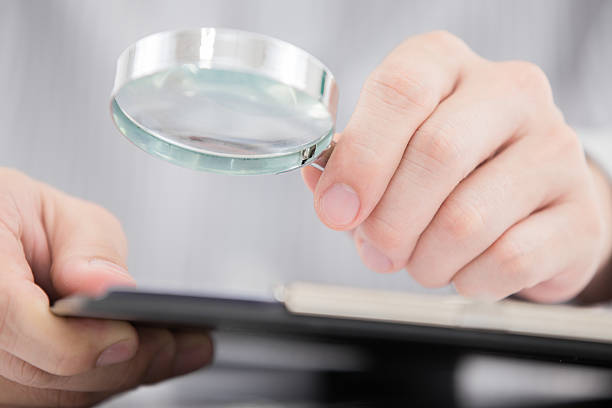 istock Businessman looking through a magnifying glass 466066425