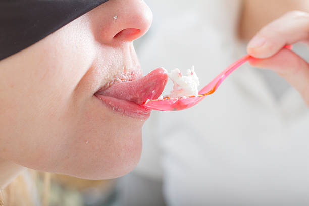 blindfolded mujer joven degustación de helado - spoon tasting women sex symbol fotografías e imágenes de stock