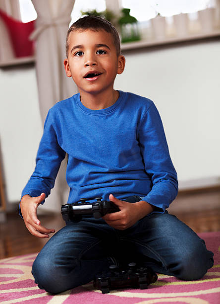 istock Young boy playing video game, at home. 466071888