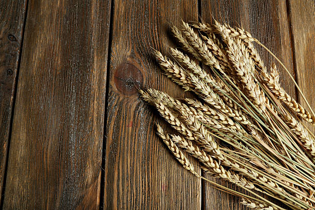istock Wheat ears on brown wooden background 466072970