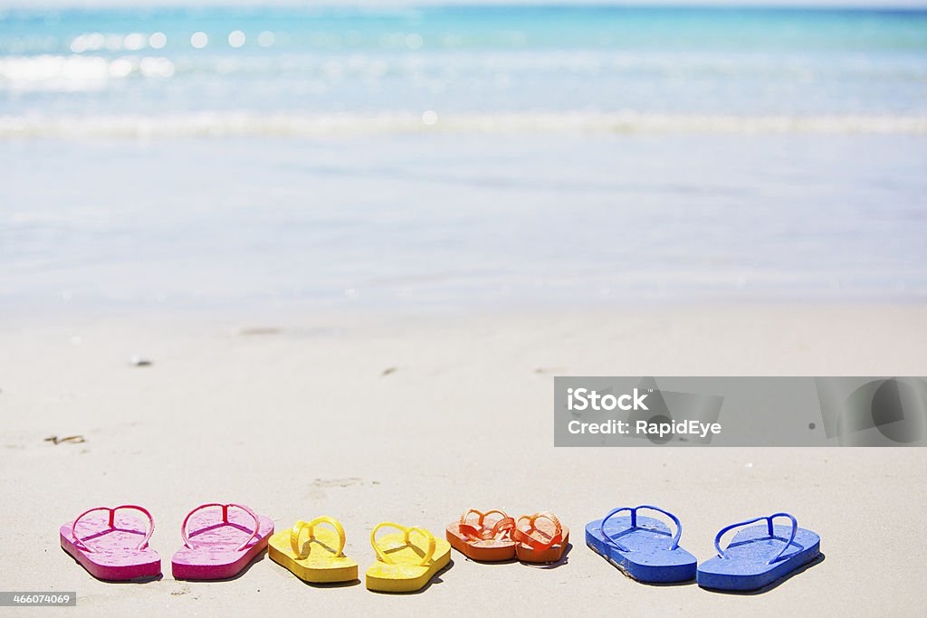 Diversión para sus vacaciones familiares symbolized por cuatro pares de flipflops bien - Foto de stock de Familia libre de derechos