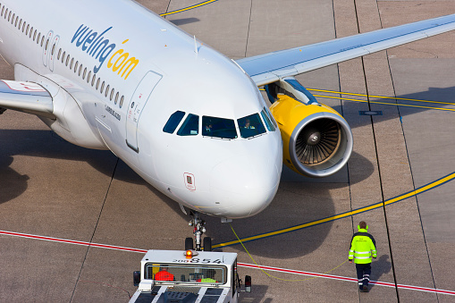 Düsseldorf, Germany - March 07, 2015: Airbus A320 from the Spanish low cost carrier Vueling at the Düsseldorf International Airport. Ground staff is preparing the aircraft for takeoff.