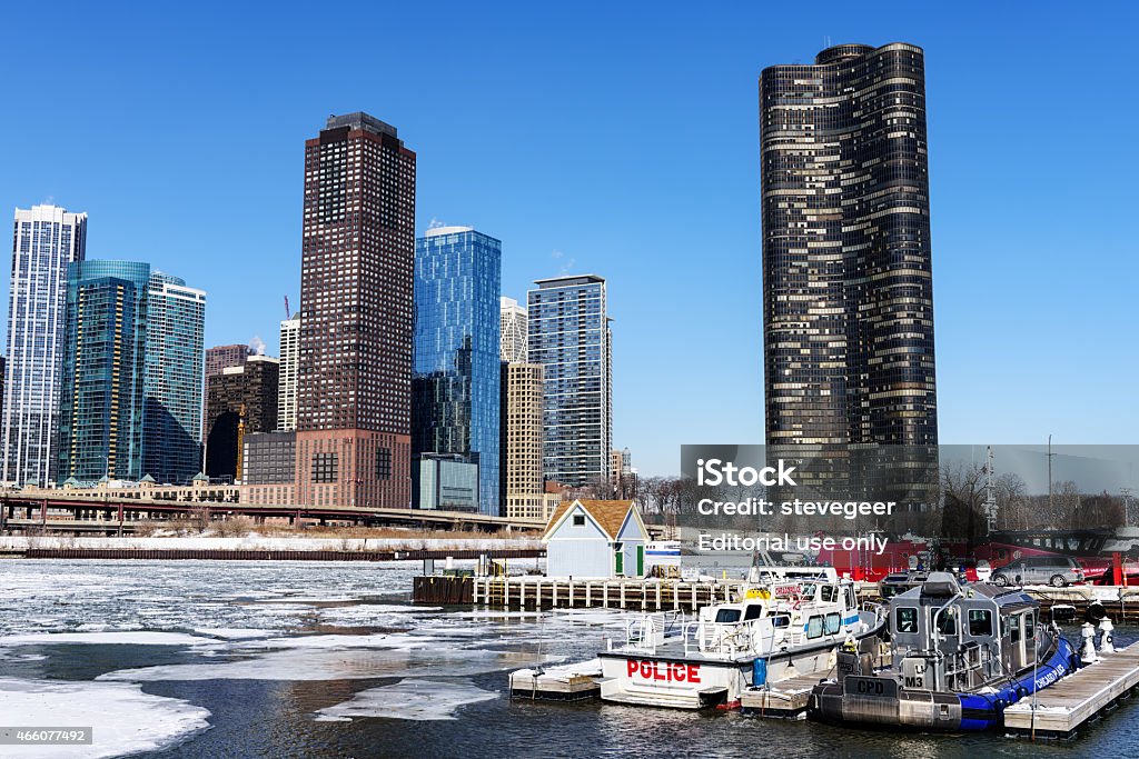 Police boats and skyscrapers, mouth of frozen Chicago River Chicago, USA - February 28, 2015: Polce boats at the mouth of the Chicago River in Chicago. Lake Point Tower and apartment skyscrapers in Streerville in the background. Ice on river. No people. Apartment Stock Photo