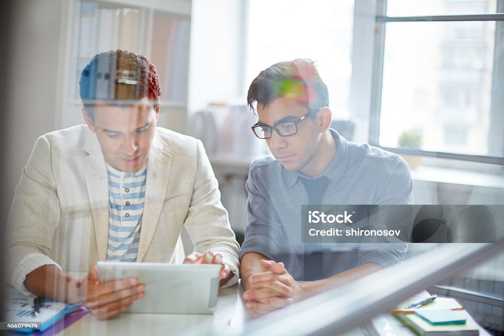 Colleagues networking Two young businessmen using digital tablet in office 2015 Stock Photo