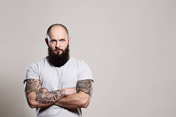 бородатый человек с скрещенные руки - arm tattoo стоковые фото и изображения