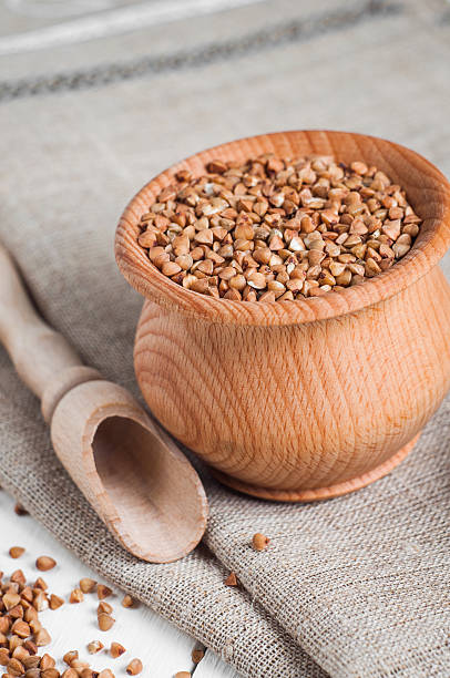 istock buckwheat in a wooden bowl on white background 466084382