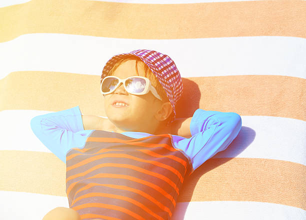 istock cute little boy lying on towel at summer beach 466086368