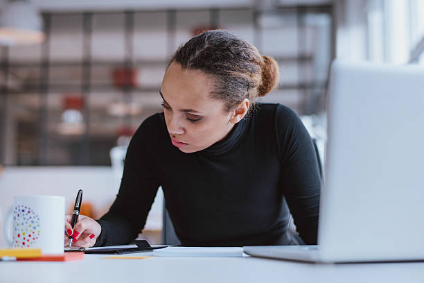 istock Woman in black working at her desk 466086690