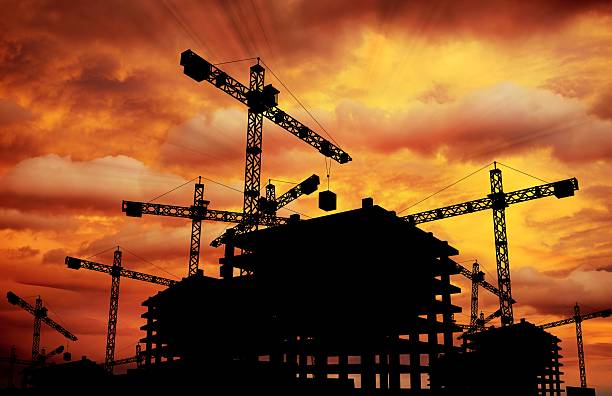 Construction Sunset Construction Sunset Theme. Construction Cranes and Building Silhouette. construction skyscraper machine industry stock pictures, royalty-free photos & images