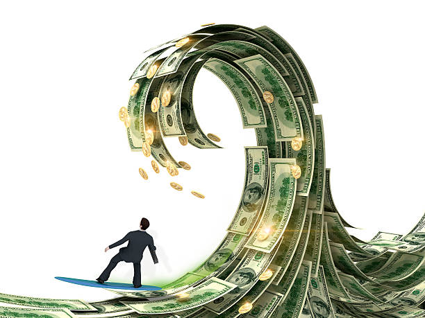businessman slips surfing on a wave of money stock photo