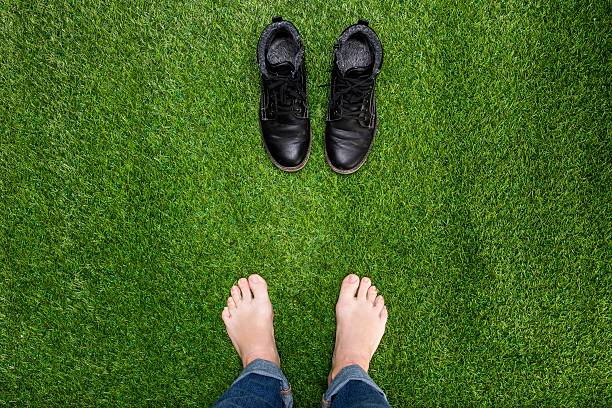 istock Feet resting on green grass with standing opposite boots 466092108