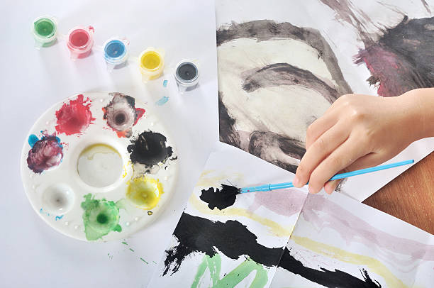 Mão de criança Pintura com Pincel e Cor - fotografia de stock