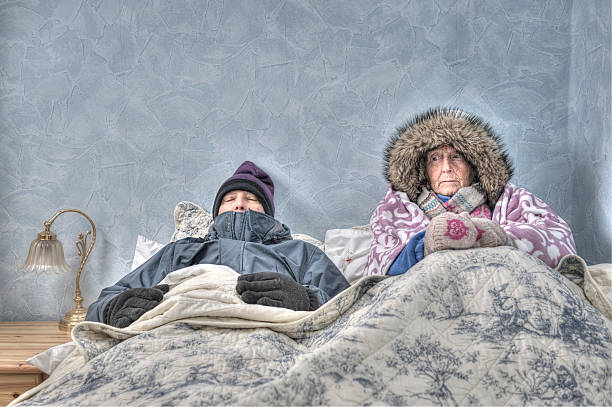 Senior couple, cold and miserable in bed stock photo