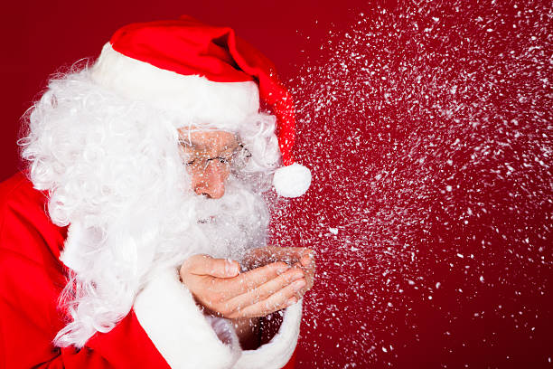 istock Portrait of santa blowing snow 466098025
