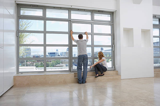 istock Couple Looking Out Of Window In Empty Apartment 466098244