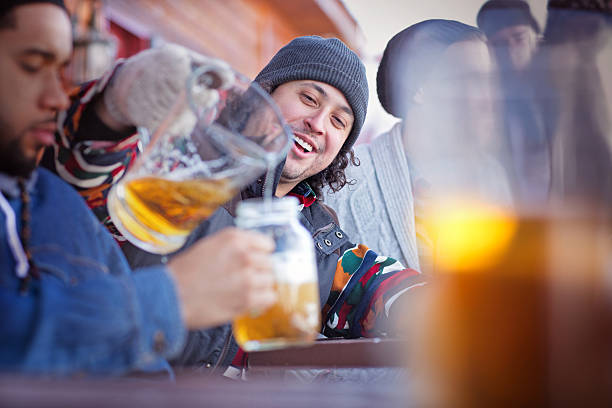 Friends Having Good Times After Skiing A group of friends having beer after skiing. apres ski party winter cabin stock pictures, royalty-free photos & images