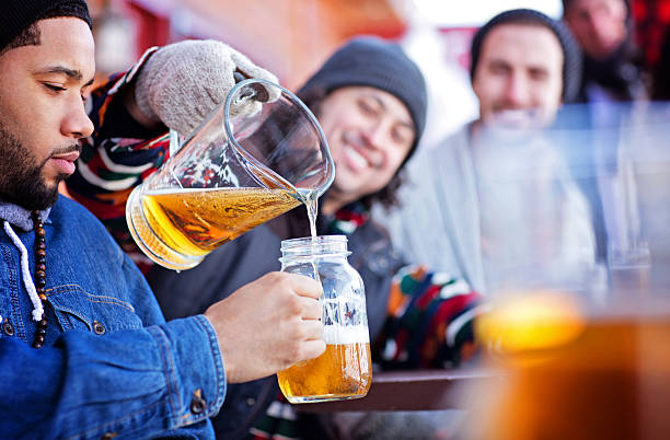 Friends Having Good Times After Skiing A group of friends having beer after skiing. Note to inspector: The model releases are in the width of 1275 pixel and all fields are legible. Please zoom in 100%. apres ski party winter cabin stock pictures, royalty-free photos & images