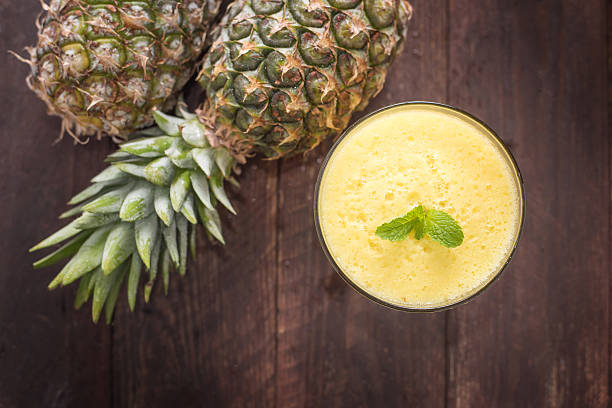 istock Top pineapple smoothie on wooden table 466104520
