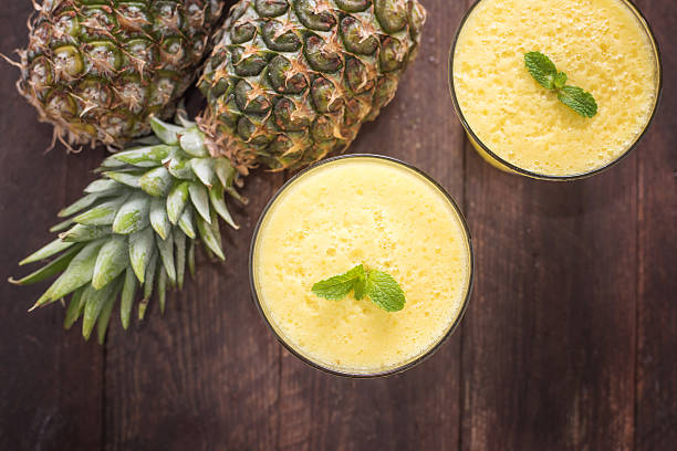 istock Top pineapple smoothie on wooden table 466104524