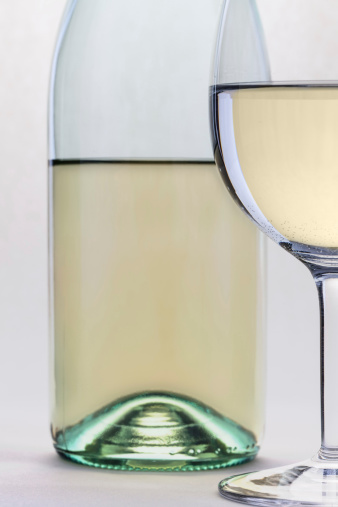 White wine glass and bottle closeup islolated on white background