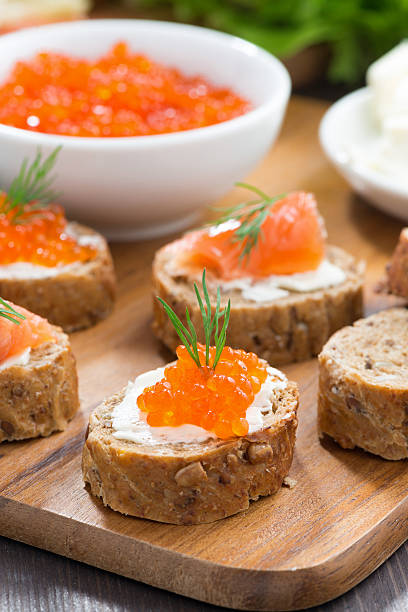 aperitivos, tostadas con el salmón salado y caviar rojo, vertical - plank bread caviar close up fotografías e imágenes de stock