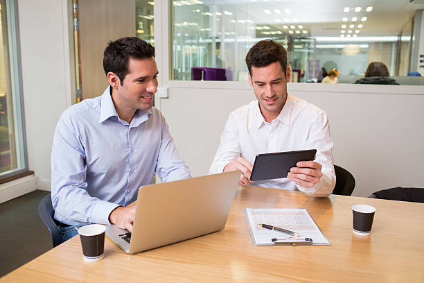 istock Two casual businessmen working together in modern office with la 466111797