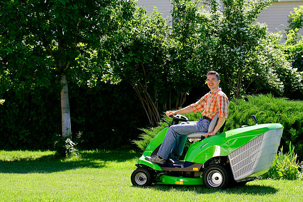 mann auf dem rasenmäher - lawn mower tractor gardening riding mower stock-fotos und bilder