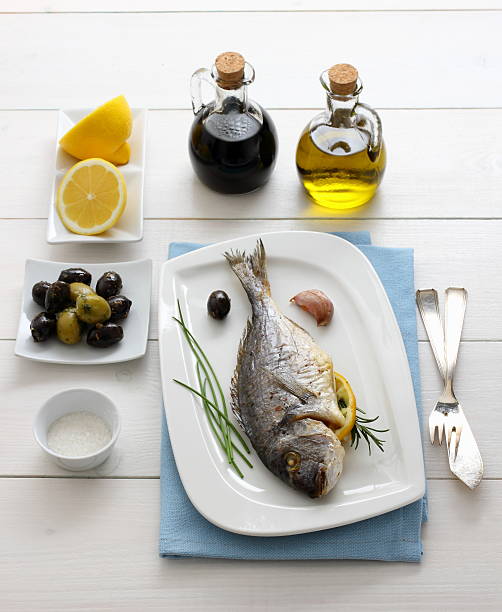 istock Garnished grilled sea bream with olives, lemon 466124506